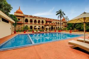 a swimming pool in front of a building at WelcomHeritage Shivavilas Palace, HAMPI in Hospet