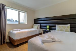 Habitación de hotel con 2 camas y ventana en Hanmer Springs Retreat en Hanmer Springs
