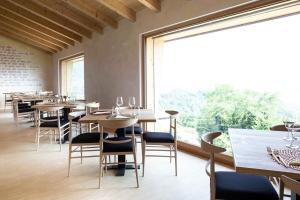 a restaurant with tables and chairs and a large window at Maso al Sole Agriturismo in Civezzano