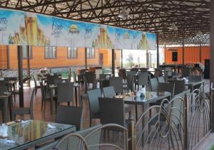 um restaurante com mesas e cadeiras e um grande ecrã em Арасан Алаколь em Qabanbay