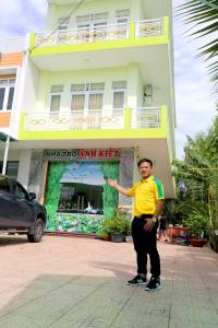 a man standing in front of a building at Motel Anh Kiệt - Vườn Quốc Gia Tràm Chim in Tràm Chim