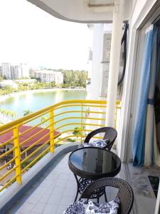 a balcony with a table and chairs and a view of the water at The Whale - Bayview - Pool open in Port Dickson