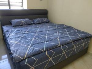 - un lit avec une couette bleue et 2 oreillers dans l'établissement The Whale - Bayview - Pool open, à Port Dickson
