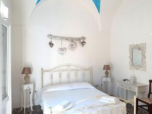 biała sypialnia z łóżkiem i lustrem w obiekcie B&B Antiche Stelle Salento w mieście Salve