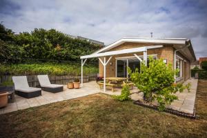 a patio with a pavilion and a table and chairs at Huize Mamoesh in De Panne