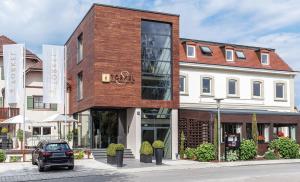 um edifício com uma fachada de vidro numa rua da cidade em Hotel Restaurant Spa Torkel em Nonnenhorn