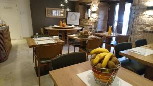 a restaurant with tables and chairs and a bowl of bananas at Hotel Pura Vida in Valgañón