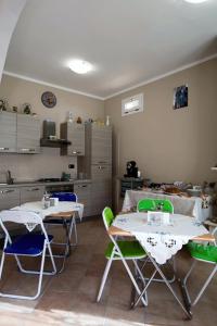 due tavoli e sedie in una stanza con cucina di B&B Passalacqua a Ortona