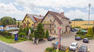 ein großes Gebäude mit Autos auf einem Parkplatz in der Unterkunft Mister in Mielno