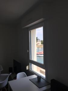 a window in an office with a view of the water at Appartement Design VII Port de Tréboul-Douarnenez in Douarnenez