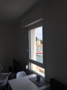 een raam in een kantoor met uitzicht op het water bij Appartement Design VII Port de Tréboul-Douarnenez in Douarnenez