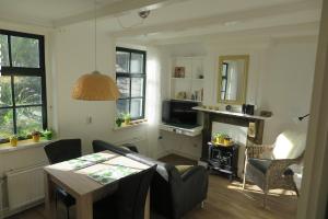 a living room with a table and a television at Het Kunstenaarshuis in Kamperland