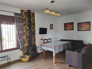 Una sala de estar con una mesa y una chimenea. en Alojamientos Rurales La Esperanza, en Arriate