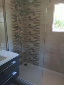 uma casa de banho com um chuveiro e uma porta de vidro em Le Pech de Sireuil em Groléjac