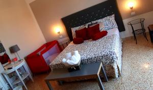 a bedroom with a large bed with red pillows and a table at 5 cupole in Palermo