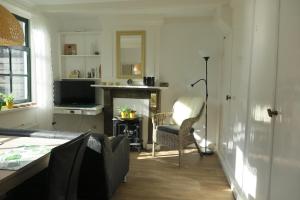 a living room with a fireplace and a chair at Het Kunstenaarshuis in Kamperland +13 photos