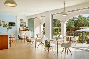 un restaurante con mesas y sillas y un patio en Sappho Hotel en Párga
