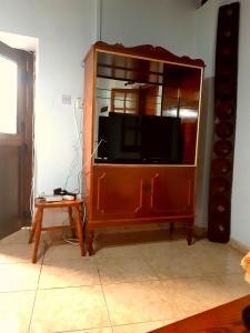 a large wooden entertainment center with a television in it at John' s House in Omodos in Limassol