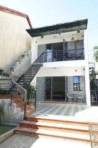 a white house with stairs and a balcony at Kha Nguyen Apartment 2-Near Hoi An Old town in Hoi An