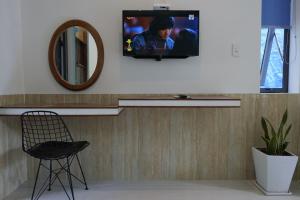 会安Kha Nguyen Apartment 2-Near Hoi An Old town的墙上的电视,带椅子和镜子