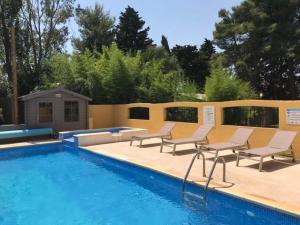 een zwembad met stoelen en een tafel en een zwembad bij Résidence les Caraibes in Sérignan