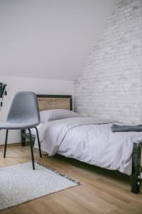 a bedroom with a bed and a chair at Schöndorf Hostel - virtual reception in Bratislava