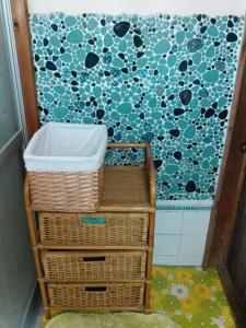 baño con cestas y pared azul y blanca en 昭和の宿 汐凪 shionagi, en Towa
