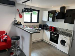a kitchen with a sink and a washing machine at Manifique Maison T2 50m2 Atypique wifi & parking privée in Oullins