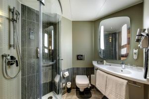 a bathroom with a sink and a toilet and a mirror at ibis Wien Hauptbahnhof in Vienna