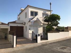 ein weißes Haus mit einem Tor und einem Zaun in der Unterkunft Villa Julia in Ayia Napa