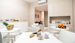 - une cuisine blanche avec des tables et des chaises blanches dans l'établissement B&B Blanc, à Pescara