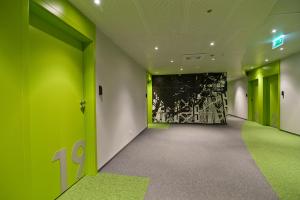 an empty hallway with green walls and a painting at Green Hotel Płock in Płock
