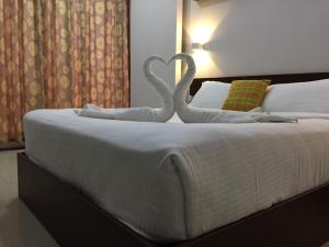 two swans made out of towels on a bed at The Cliff Resort, Munnar in Munnar