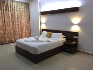 a bedroom with a large bed with a large window at The Cliff Resort, Munnar in Munnar