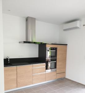 a kitchen with wooden cabinets and stainless steel appliances at Gîtes de Maurs in Maurs