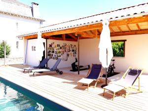 une terrasse en bois avec des chaises et une piscine dans l'établissement Gîtes de Maurs, à Maurs