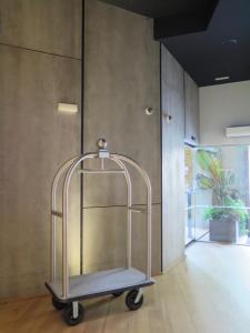 a metal luggage cart in a room with a wall at Hotel Tayko Bilbao in Bilbao