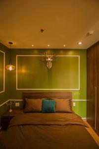 um quarto com uma cama com uma parede verde em Full House Condotel - Căn hộ 606 Dalat Center em Da Lat