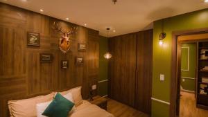 um quarto com paredes verdes e uma cama com cabeça de veado na parede em Full House Condotel - Căn hộ 606 Dalat Center em Da Lat