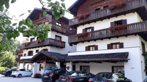 a building with cars parked in front of it at Hotel Principe in Cortina dʼAmpezzo