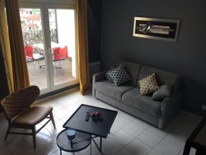 een woonkamer met een bank en een tafel bij Résidence Studio Grand Luxe Wifi parking privé in Vaulx-en-Velin