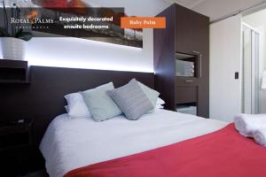 1 dormitorio con 1 cama grande con manta roja en Royal Palms Guest House, en Port Elizabeth