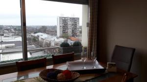 a table with two wine glasses and a large window at Los Naranjeles Centro Flat in Salto