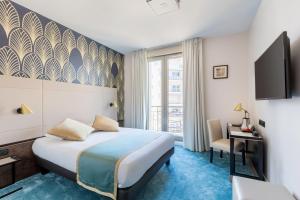 a hotel room with a bed and a desk and a window at Best Western Hôtel Journel Antibes Juan-les-Pins in Antibes