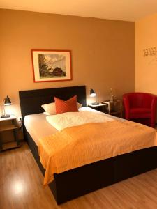 um quarto com uma cama e uma cadeira vermelha em Hotel Restaurant Denis em Zemmer