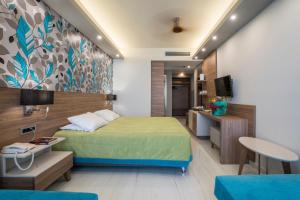 a hotel room with a bed and a tv at Atrion Resort Hotel in Agia Marina Nea Kydonias