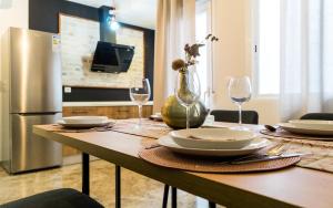 een tafel met borden en glazen en een koelkast bij Capitulares 2 in Córdoba