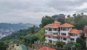 um grande edifício branco com um telhado laranja em The Heaven's Villa Kandy em Kandy