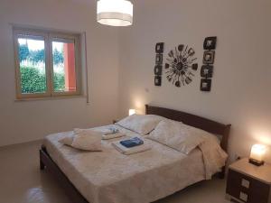 a bedroom with a bed with two pillows and a clock at Italian charm, modern elegance in Pizzo in Pizzo +54 photos
