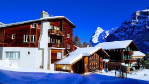 un edificio en la nieve con una montaña en el fondo en Chalet Anemone 2, en Mürren